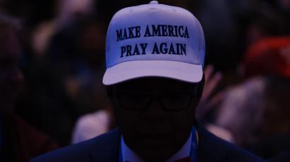 Ein Mann mit einem Hut mit der Aufschrift "Make America Pray Again" an einer Veranstaltung an der Donald Trump spricht
