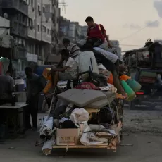 Männer sitzen auf vollbepacktem Wagen in Gaza